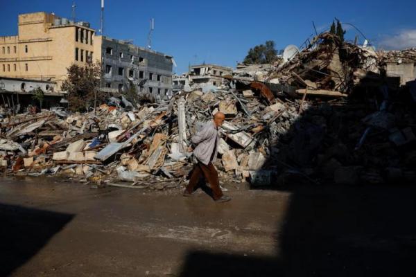 Seorang pria berjalan melewati puing-puing bangunan yang hancur di kota Nabatieh, Lebanon selatan, 28 November 2024. REUTERS 