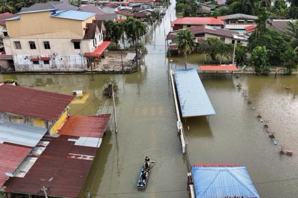 Pemandangan drone menunjukkan orang-orang menaiki perahu di daerah pemukiman yang banjir di Rantau Panjang, Malaysia, 3 Desember 2024. REUTERS 