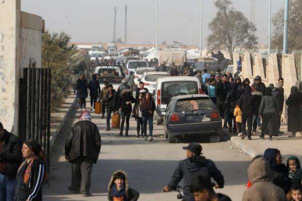 Orang-orang terlantar yang melarikan diri dari pedesaan Aleppo berjalan melewati mobil-mobil di Tabqa, Suriah 4 Desember 2024. REUTERS 