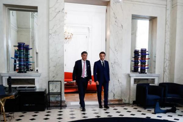 Presiden Prancis Emmanuel Macron berjalan di samping Sekretaris Pertama Partai Sosialis Olivier Faure di Istana Elysee di Paris, Prancis, 21 Juni 2022. Foto via REUTERS 