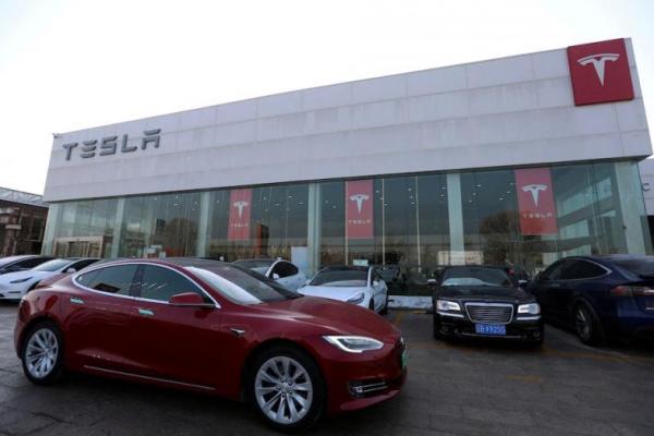 Mobil Tesla dikemudikan melewati toko pembuat kendaraan listrik di Beijing, Tiongkok, 4 Januari 2024. REUTERS 