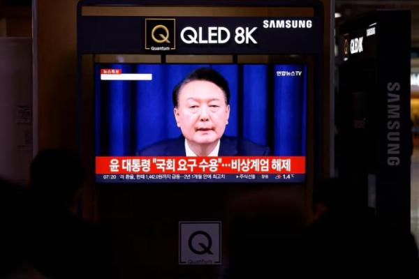 Orang-orang menonton layar TV yang menyiarkan deklarasi darurat militer Presiden Korea Selatan Yoon Suk Yeol di sebuah stasiun kereta api di Seoul, Korea Selatan, 4 Desember 2024. REUTERS 