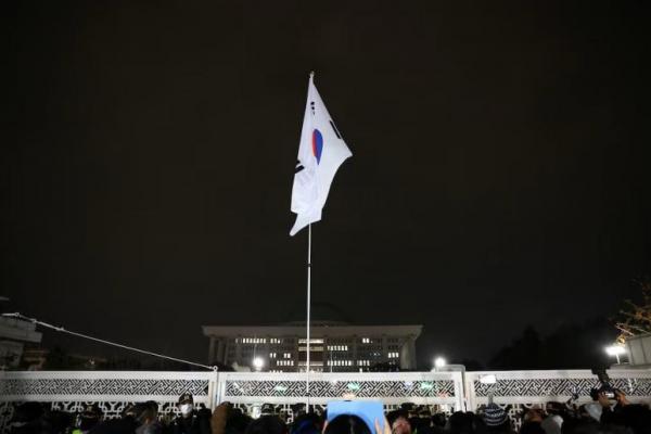 Bendera Korea Selatan tergantung di tiang di luar gerbang Majelis Nasional, di Seoul, Korea Selatan, 4 Desember 2024. REUTERS 