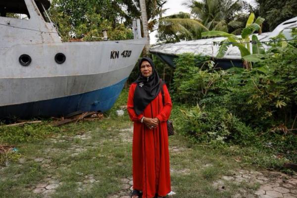 Saudah, 64, seorang penyintas tsunami Samudra Hindia, berpose di depan rumahnya di pusat kota Banda Aceh, Indonesia, 21 Desember 2024. REUTERS 