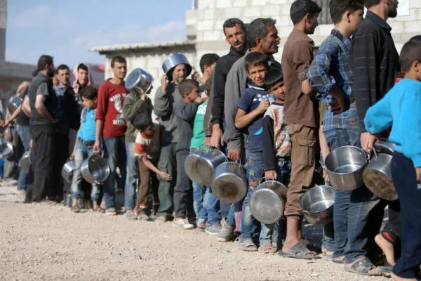 Pengungsi Suriah dari Ghouta Timur mengantre makanan di tempat penampungan Herjelleh di pedesaan Damaskus, Suriah, 15 April 2018. REUTERS 