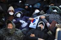 Demonstran pro-Yoon berbaring di tanah di luar kediaman resmi Presiden Korea Selatan Yoon Suk Yeol di Seoul, Korea Selatan, 2 Januari 2025. REUTERS