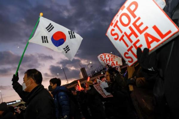 Demonstran pro-Yoon memegang bendera Korea Selatan dan pamflet saat unjuk rasa di dekat kediaman resmi Presiden Korsel di Seoul, Korea Selatan, 4 Januari 2025. REUTERS 