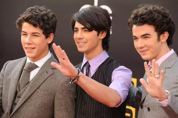 Joe Jonas (tengah) dan Kevin Jonas (kanan) memamerkan cincin kemurnian mereka pada tahun 2008 bersama saudara lelakinya Nick Jonas (kiri). (FOTO: FILM MAGIC) 