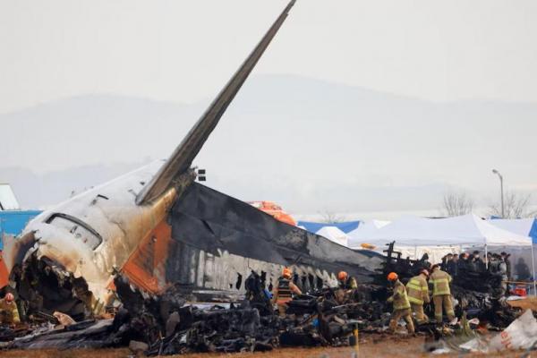 Orang-orang bekerja di lokasi jatuhnya Jeju Air di Bandara Internasional Muan, Korea Selatan, 30 Desember 2024. REUTERS 