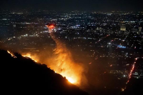 Helikopter mendinginkan Kebakaran Palisades yang terjadi di Pacific Palisades, California, LA. (FOTO: AFP) 