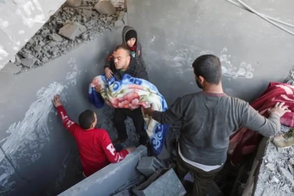 Warga Palestina membawa jenazah seorang anak di lokasi serangan Israel terhadap sebuah rumah di Nuseirat, Jalur Gaza bagian tengah. (FOTO: REUTERS) 