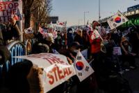 Demonstran pro-Yoon memegang bendera AS dan Korea Selatan saat unjuk rasa di dekat kediaman resmi Yoon di Seoul, Korea Selatan 10 Januari 2025. REUTERS