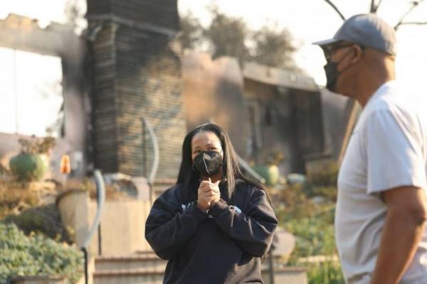 Inez Moore dan ayahnya Michael Moore berdiri di dekat rumah keluarga mereka yang terbakar di Altadena, California, AS, 9 Januari 2025. REUTERS 