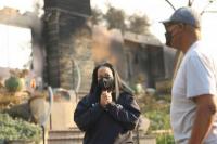 Inez Moore dan ayahnya Michael Moore berdiri di dekat rumah keluarga mereka yang terbakar di Altadena, California, AS, 9 Januari 2025. REUTERS