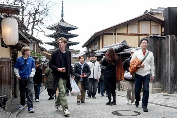 Turis berjalan melalui jalan-jalan Higashiyama-ku di Kyoto, Jepang pada 13 Januari 2025. (FOTO: AFP) 