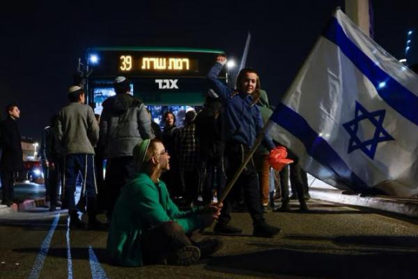 Seseorang memegang bendera Israel saat warga memblokir jalan memprotes kesepakatan gencatan senjata di Yerusalem, 16 Januari 2025. REUTERS 