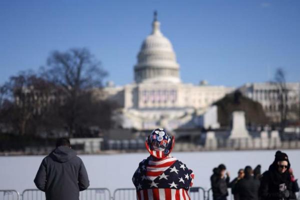 Orang-orang berdiri saat kolam belakang Gedung Capitol AS di Washington, AS, 17 Januari 2025. REUTERS 