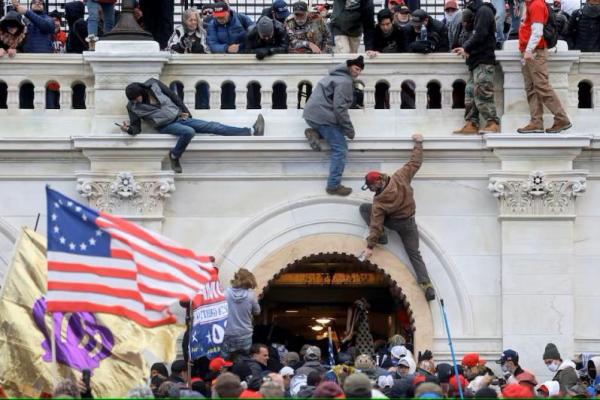 Sekelompok pendukung Presiden AS Donald Trump berkelahi dengan anggota penegak hukum saat menyerbu Gedung Capitol AS di Washington, AS, 6 Januari 2021. REUTERS 