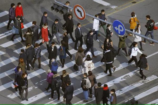 Orang-orang menyeberangi zebra cross di kawasan bisnis di pusat kota Seoul, Korea Selatan, 15 Desember 2015. REUTERS 