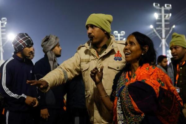 Seorang polisi mengawal seorang penyembah setelah berdesak-desakan sebelum Festival Teko Besar, di Prayagraj, India, 29 Januari 2025. REUTERS 