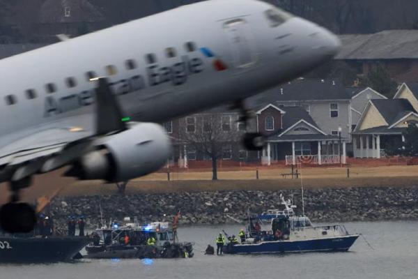 Sebuah pesawat American Eagle berangkat dari Bandara Nasional Ronald Reagan Washington, saat tim penyelamat bekerja di dekatnya, di Arlington, Virginia, AS, 31 Januari 2025. REUTERS 