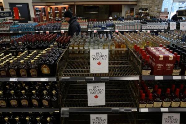 Seorang pelanggan melihat botol-botol yang dipajang dan rak kosong bertuliskan: Beli Produk Kanada Sebagai Gantinya, di Vancouver, British Columbia, Kanada, 2 Februari 2025. REUTERS 