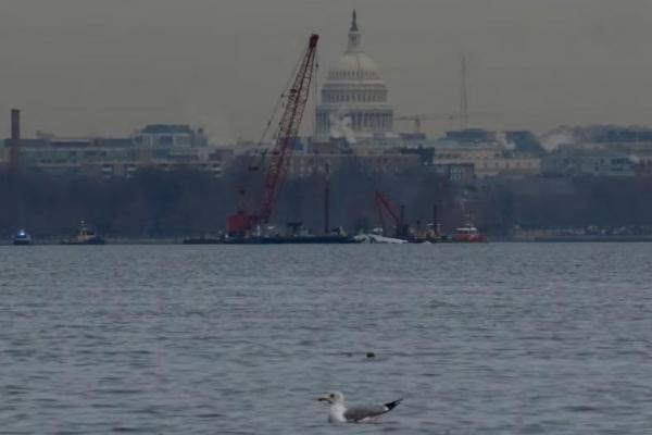 Pekerja mengangkat sisa-sisa reruntuhan di Sungai Potomac, setelah tabrakan pesawat American Eagle 5342 dan helikopter Black Hawk, seperti yang terlihat dari Virginia, AS, 3 Februari 2025. REUTERS 