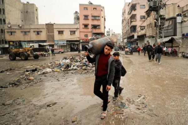 Seorang warga Palestina membawa tabung gas untuk memasak, di Kota Gaza, 3 Februari 2025. REUTERS 