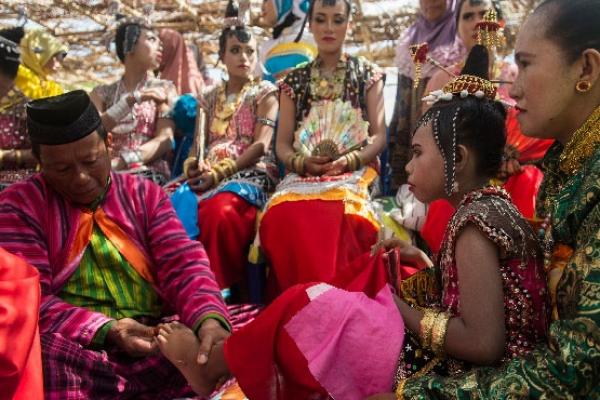 Anak perempuan menjalani prosesi injak tanah atau landa huta dalam Karia Henauka Wowine di festival Barata Kahedupa di Pulau Kaledupa, Kabupaten Wakatobi, Sulawesi Tenggara. Karia Henauka Wowine dilakukan setelah anak perempuan dalam keluarga disunat atau dipingit untuk perempuan yang telah dianggap dewasa (Foto: Antara) 