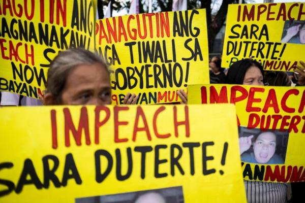 Aktivis membawa spanduk yang menyerukan pemakzulan Wakil Presiden Filipina Sara Duterte di luar DPR di Quezon City, Metro Manila, Filipina, 5 Februari 2025. REUTERS 