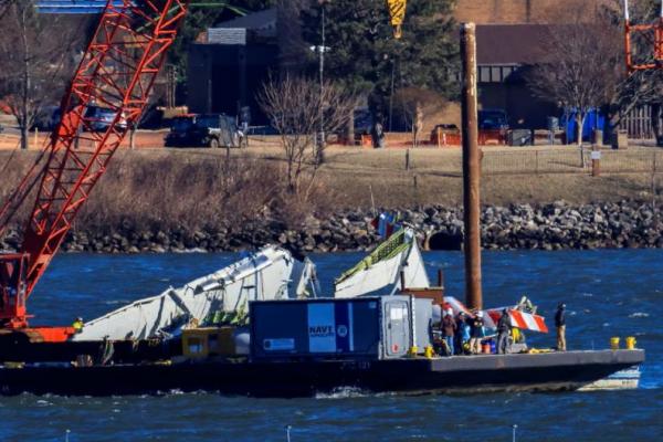 Sebuah derek mengangkat sebagian puing pesawat dan helikopter dari Sungai Potomac, di Arlington, Virginia, AS, 4 Februari 2025. REUTERS 