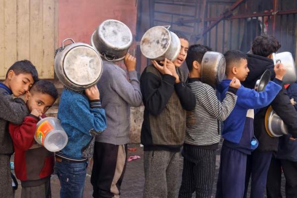 Anak-anak Palestina membawa panci saat mengantre untuk menerima makanan yang dimasak oleh dapur amal di Rafah di Jalur Gaza selatan, 14 Desember 2023. REUTERS 