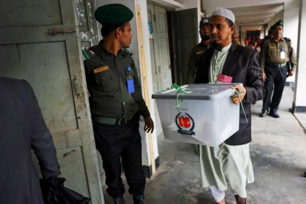 Seorang petugas membawa kotak suara untuk menghitung suara saat pemilihan umum ke-12 di Dhaka, Bangladesh, 7 Januari 2024. REUTERS 