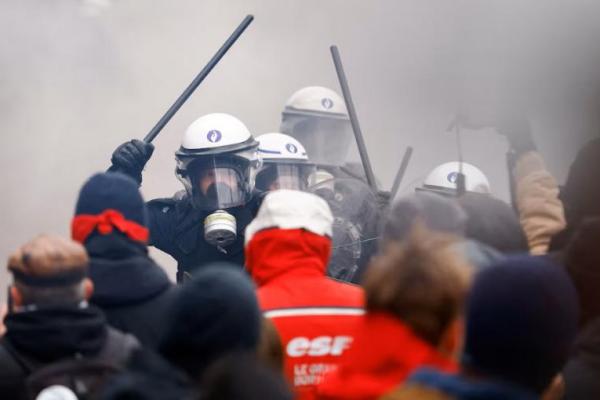 Polisi antihuru-hara mengacungkan tongkat menghadapi demonstran dalam aksi mogok nasional di Brussels, Belgia 13 Februari 2025. REUTERS 