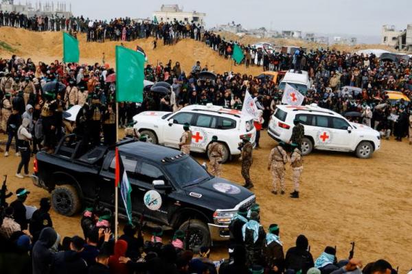 Militan Palestina dan anggota Palang Merah berkumpul di dekat kendaraan pada hari Hamas menyerahkan sandera yang telah meninggal di Khan Younis di Jalur Gaza selatan, 20 Februari 2025. REUTERS 