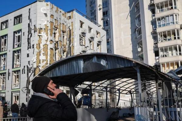 Seorang warga berdiri di lokasi gedung apartemen dan klinik yang terkena serangan pesawat nirawak Rusia, di Odesa, Ukraina, 19 Februari 2025. REUTERS 