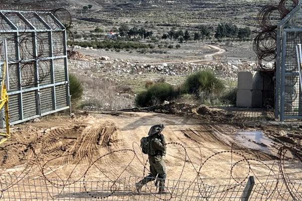 Seorang tentara Israel berjalan melewati garis gencatan senjata dengan Suriah dan Dataran Tinggi Golan yang diduduki Israel. (FOTO: REUTERS) 