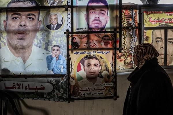 Najat berdiri di depan poster Diaa yang tergantung di rumah mereka yang rusak. (FOTO: AL JAZEERA) 