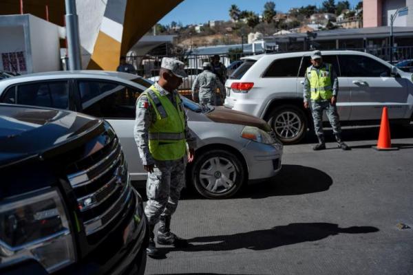 Anggota Garda Nasional Meksiko memeriksa kendaraan yang mengantre untuk menyeberang ke AS di Nogales, Sonora, Meksiko, 22 Februari 2025. REUTERS 