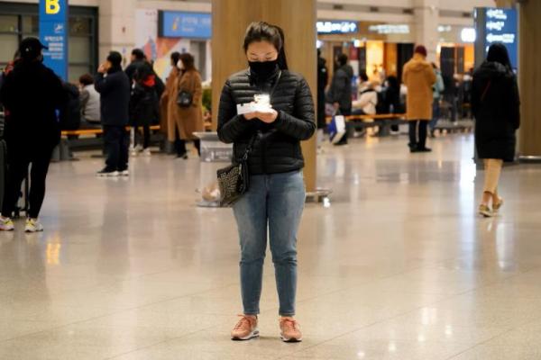 Seorang wanita memeriksa tiket di ponselnya di Bandara Internasional Incheon di Incheon, Korea Selatan, 3 Januari 2020. REUTERS 