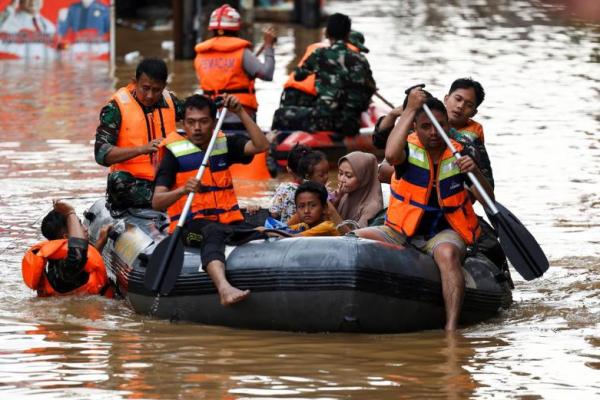 Tim penyelamat mengevakuasi orang-orang menggunakan perahu karet dari daerah pemukiman yang banjir setelah hujan lebat di Jakarta, Indonesia. REUTERS 