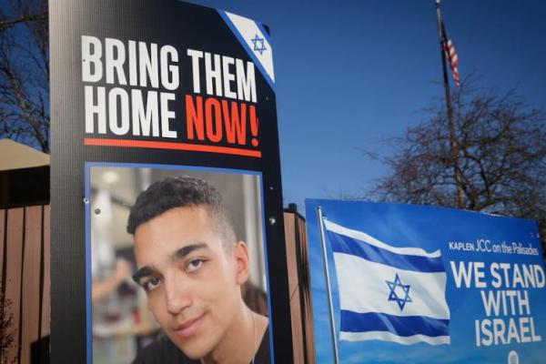 Tanda dan foto Edan Alexander, prajurit Amerika-Israel, di luar pusat komunitas Yahudi di kota asal Alexander, Tenafly, New Jersey, AS, 14 Desember 2024. REUTERS 