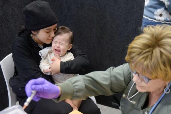 Devonay Pena menghibur putrinya yang berusia 13 bulan, setelah menerima dosis pertama vaksin MMR di Departemen Kesehatan Kota Lubbock di Lubbock, Texas, AS, 27 Februari 2025. REUTERS 