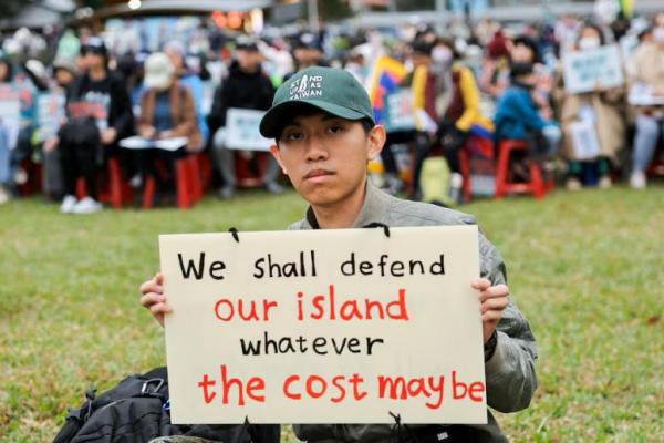 Seorang pria berpose dengan plakatnya sendiri di rapat umum di Taipei, Taiwan 8 Desember 2024 REUTERS 