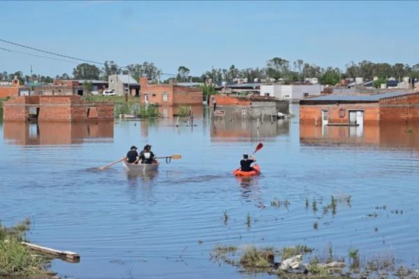 Orang-orang mendayung kayak di jalanan yang banjir di kota Bahia Blanca, provinsi Buenos Aires. (FOTO: REUTERS) 