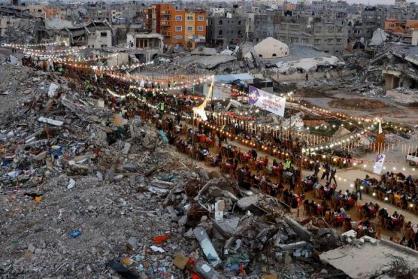 Warga Palestina berbuka puasa selama bulan suci Ramadan, di dekat reruntuhan bangunan, di Rafah, Jalur Gaza selatan, 1 Maret 2025. REUTERS 