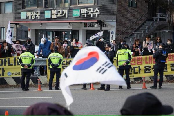 Anggota polisi berjaga saat pendukung Presiden Korea Selatan yang dimakzulkan Yoon Suk Yeol berdiri di luar pusat penahanan Seoul di Uiwang, Korea Selatan, 7 Maret 2025. REUTERS 